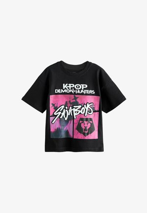 Schwarzes T-Shirt mit kurzen Ärmeln und dem Schriftzug „KPOP DEMON HUNTERS“, einer pinkfarbenen Grafik mit Silhouetten von Figuren und einem Löwenkopf-Logo unter dem „Saijaboys“-Schriftzug.