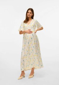 Robe maxi en beige clair avec des motifs floraux jaunes et bleus. Manches évasées et décolleté en V avec une taille élastique.