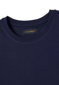 T-shirt in cotone blu navy con scollo rotondo a costine. Presenta un'etichetta con "PIOMBO" in testo giallo. Texture liscia, senza motivi.