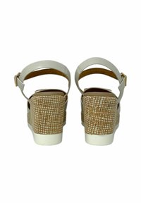 Sandali platform bianchi con tacco a zeppa texturizzato color tan, caratterizzati da una fascia liscia con una fibbia metallica e un design aperto sul retro.