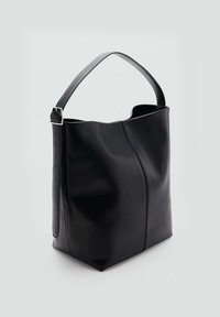 Bolso tote de piel negra con un diseño estructurado, textura suave y una correa ajustable. Presenta una costura única en el frente.
