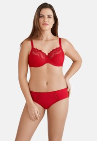 Rode bh met kantafwerking, voorzien van beugel en verstelbare bandjes, gecombineerd met bijpassende rode boyshorts met kantaccenten en een gladde textuur.