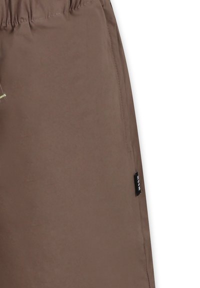 Shorts marroni realizzati in un tessuto leggero e liscio; presentano una vita elastica e una piccola etichetta con il marchio sul lato.