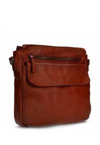 Bruine leren schoudertas met een klep, een ritsvak aan de voorkant en een verstelbare schouderband. Zachte textuur en rechthoekige vorm.