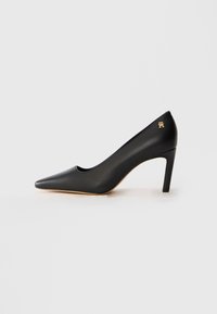 Black leather pointed-toe high heel shoe with mid-height stiletto heel and small gold emblem near heel on white background.