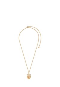 Kuldne kaelakee, millel on ümmargune ripats tekstuurse pinnaga ja stiliseeritud punane täht "T" keskel, kinnitatud lukuga.