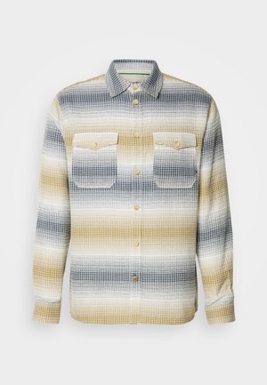 Tkanina s karelnim vzorcem v temno modri, sivi in gorčični črti, z gumbi spredaj in dvema žepoma na prsih.