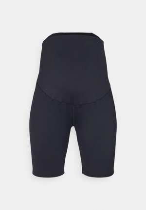Shorts neri a vita alta realizzati in tessuto elasticizzato, con una superficie liscia e un design senza cuciture, che arrivano appena sopra il ginocchio.