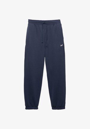 Pantaloni de trening bleumarin din bumbac moale. Au un brâu elastic cu șnur și manșete elastice. Logo mic pe lateral.