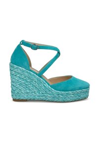 Sandalo con zeppa in suede teal, dotato di cinturino alla caviglia incrociato e piattaforma in juta intrecciata. Punta rotonda e superficie testurizzata. Altezza della zeppa: circa 3 pollici.