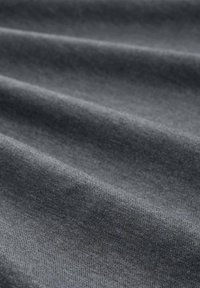 Szary tekstylia o gładkiej fakturze, prezentujące delikatne fałdy i subtelne zróżnicowania odcieni, wskazujące na lekki materiał.