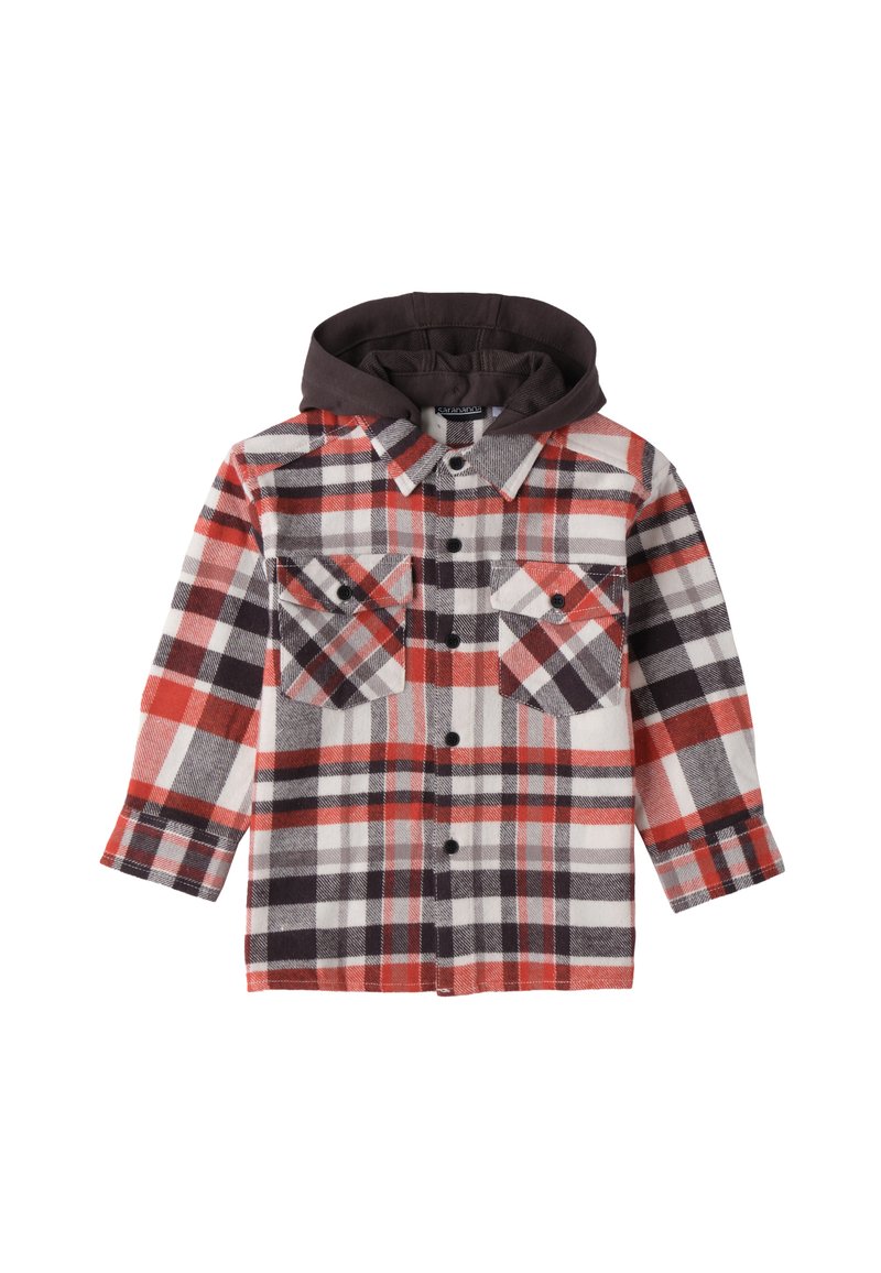 Camicia di lana a quadri in rosso, nero e bianco. Presenta un cappuccio marrone, due tasche sul petto con chiusura a bottoni e una chiusura frontale con bottoni.