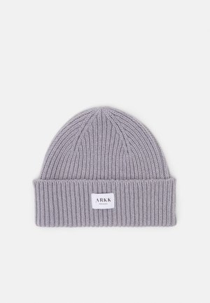Gray knit beanie with a ribbed texture, featuring a folded cuff and a small rectangular label with "ARKK" branding.