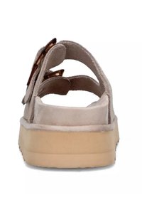 Lichtbeige suède sandaal met drie verstelbare banden en decoratieve hardware. Dikke crèmekleurige zool met een gestructureerde grip. Achteraanzicht, ontwerp met open achterkant.