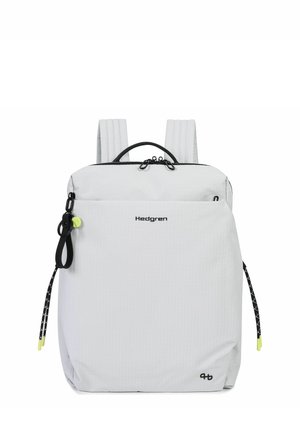 White Hedgren backpack with two padded shoulder straps, front zip pocket, black handle, and black zipper pulls with yellow accents.