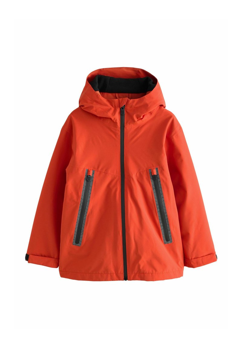 Giacca impermeabile arancione con cappuccio, chiusura frontale con zip e due tasche diagonali con zip con dettagli neri testurizzati. Finitura del tessuto liscia.