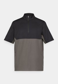 Πολυτελές πόλο κοντό μανίκι με κολάρο μισού φερμουάρ, που διαθέτει μαυρή επάνω και γκρίζα κάτω τμήματα, κατασκευασμένο από απαλό ύφασμα με ελάχιστες ραφές.