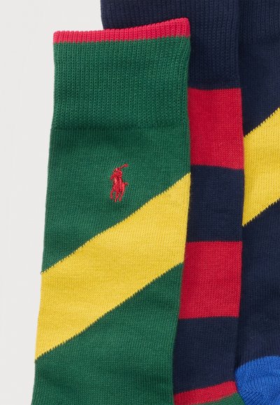 Δύο ζευγάρια πολύχρωμες πλεκτές κάλτσες, ένα πράσινο με κίτρινη διαγώνια λωρίδα και κόκκινο λογότυπο παίκτη πόλο, το άλλο μπλε σκούρο με κόκκινες και κίτρινες ρίγες.