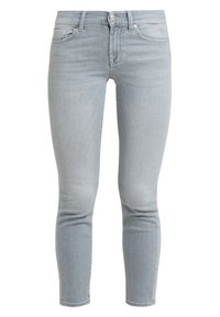 Jeans in denim grigio chiaro con design aderente, cinque tasche, patta con zip e chiusura a singolo bottone. Texture liscia e finitura pulita.