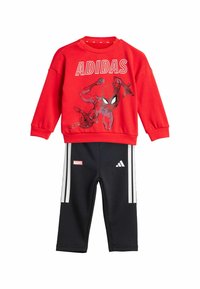 Sudadera roja con gráfico de Spider-Man y texto "ADIDAS"; pantalones negros con rayas blancas y logo "MARVEL". Mezcla de algodón, corte casual.