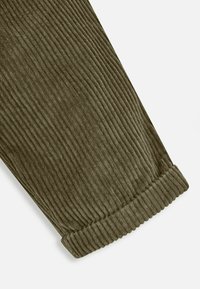Olivengroen corduroy stof met verticale ribbels, voorzien van een dikke ribbelboord aan de zoom, een zachte textuur en een getailleerde snit.