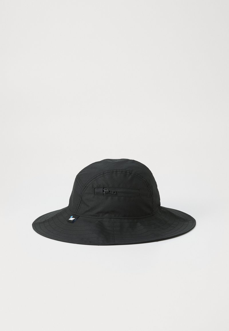 Gorra de cubo negra hecha de material suave y ligero con un ala ancha. Cuenta con un bolsillo lateral con cremallera y un pequeño parche con logo.