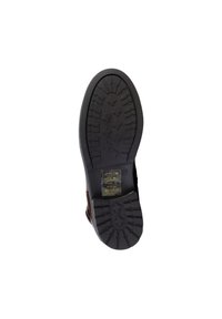 Black rubber shoe sole with textured tread featuring a flower pattern, reinforced toe area, and imprinted care instructions.