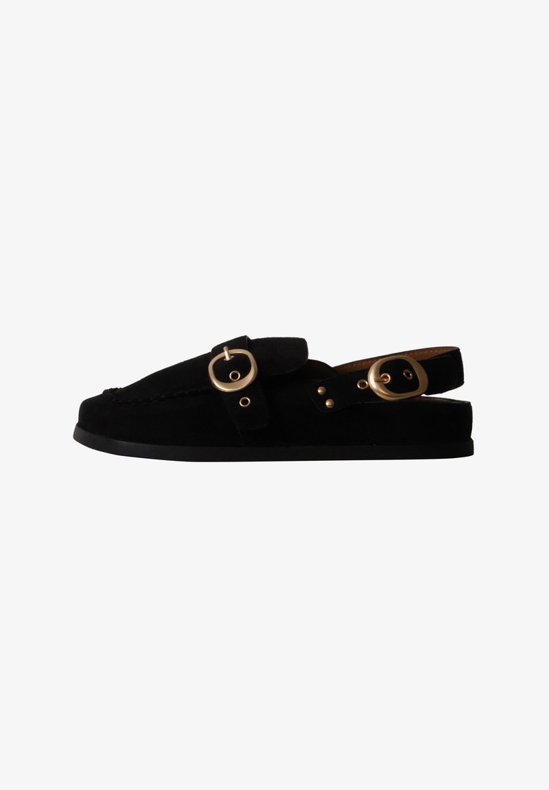 Mocassin plat en daim noir avec dos ouvert et deux boucles dorées, une sur le dessus et une sur la bride du talon.