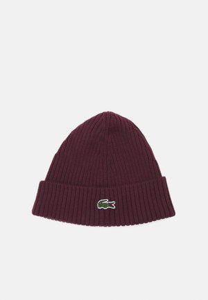 Burgundy knit beanie with a ribbed texture and folded hem, featuring a small embroidered green crocodile logo on the front.