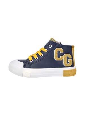Zapatilla deportiva alta azul marino con cordones amarillos, suela de goma blanca, parche amarillo en el talón y letras texturizadas "CG" en el lateral.