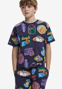 T-shirt viola a maniche corte con stampe grafiche colorate di frutta e testo, realizzato in una morbida miscela di cotone, abbinato a pantaloni corti coordinati.