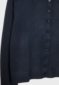 Cardigan en maille bleu marine fabriqué à partir d'un matériau doux, avec un col rond et une rangée de boutons noirs sur le devant, ourlet côtelé.