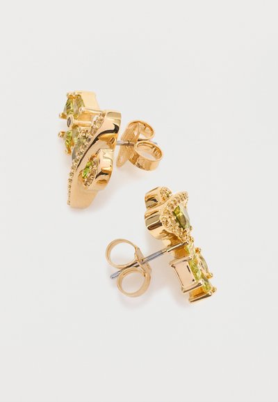 Cercei de aur cu tije, împodobiți cu pietre prețioase verzi și detalii decorative intricate pe un fundal alb simplu.