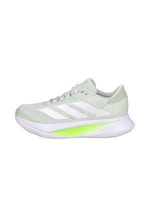 Zapatilla de running Adidas de color gris claro con logo de tres franjas blanco y suela blanca gruesa con un detalle en verde lima en el lateral.