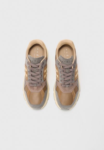 Pair of brown and beige suede and leather sneakers with laces, viewed from above on a light background.