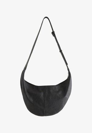Sort læder skuldertaske i halvmåneform med justerbar rem og synlig lynlås langs den øverste åbning.