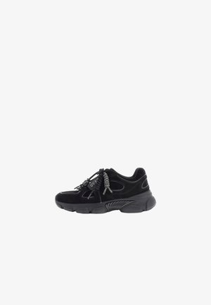 Baskets de sport noires avec une semelle épaisse, des empiècements en mesh et daim, des lacets tressés décoratifs, et le logo "GUESS" sur le côté.