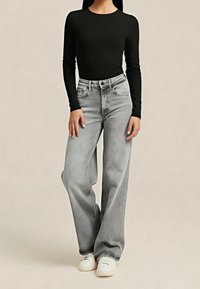 Šedé džíny širokých nohavic z denimu, kombinované s černým tričkem s dlouhým rukávem. Džíny mají vysoký pas a standardní design s pěti kapsami.