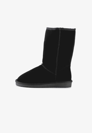 Czarne zamszowe kozak z zaokrąglonym noskiem, płaską gumową podeszwą i widocznym szwem wzdłuż szwów. Miękka faktura na całej powierzchni.