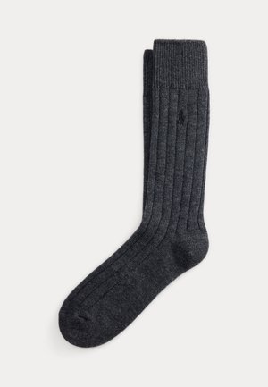 Chaussette tricotée côtelée gris foncé avec bord-côte, en vue à plat sur fond blanc, montrant toute la longueur et la texture.