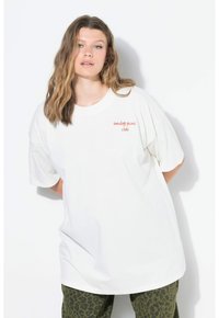 Camiseta de algodón blanca y oversize con mangas cortas, que presenta "club del picnic de domingo" impreso en rojo en el lado izquierdo.
