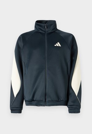 Tengerészeti színű tréningdzseki magas gallérral és cipzáros elejével. Fehér oldalsó panelek és Adidas logo a bal felső részen. Puha, sima anyag.