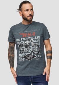 Harmaa pyöreäkaulaista t-paitaa, joka on valmistettu puuvillasta ja jossa on BSA-motonäyttelyä kuvaava graafinen printti, mustia ja punaisia tekstejä sekä teksturoitu muotoilu hihoissa.