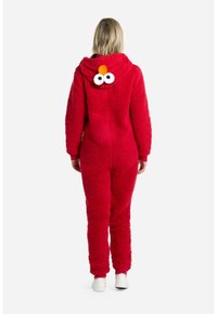 Mono rojo y esponjoso con capucha que presenta grandes ojos y una nariz naranja. Mangas largas y puños, material texturizado y un ajuste relajado.