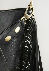 Čierna kožená kabelka s textúrovaným povrchom, zlatými kovovými prvkami a dekoratívnymi čiernymi strapcami. Obsahuje značkovú visačku vo vnútri.