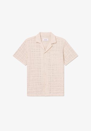 Krátky rukáv béžová košeľa z textúrovanej tkaniny s kockovaným vzorom, s gombíkovou nášivkou a jednou náprsníkou.