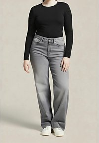 Czarna bluzka z długim rękawem w połączeniu z jasnoszarymi spodniami typu wide-leg, posiadającymi kieszenie z przodu i miękką teksturę dżinsu. Look dopełniają białe trampki.