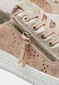 Sneaker in pelle rosa con motivo floreale perforato, dettagli metallici, zip dorata e lacci testurizzati. Suola bianca con fondo a righe.