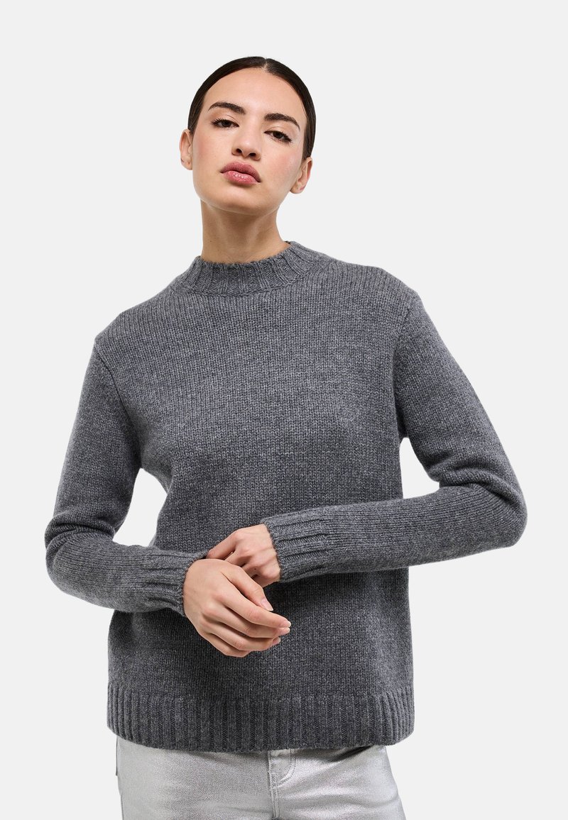 Pull en laine gris avec un col rond, des poignets et un ourlet côtelés. Présente un motif en maille texturée et une coupe décontractée.