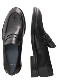 Mustad mustad nahast loafers, millel on sile pind, lai rihm ülemise osa üle ning veidi tõstetud konts madala tallaga. Siseosa on sinine.
